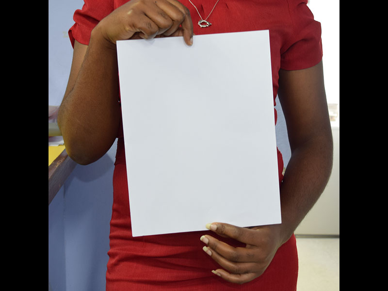 Black girl posing holding blank paper in front of her belly