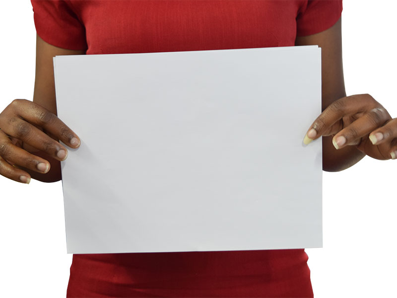 Black girl standing up holding blank paper in front of her belly