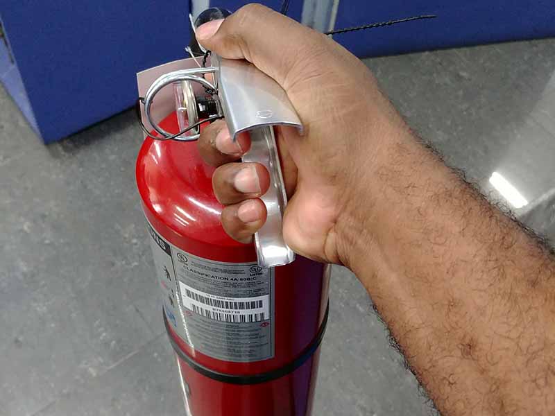 Black hands holding fire extinguisher