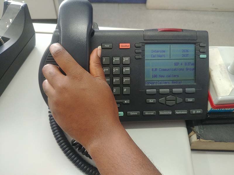 Black hands picking up telephone at work