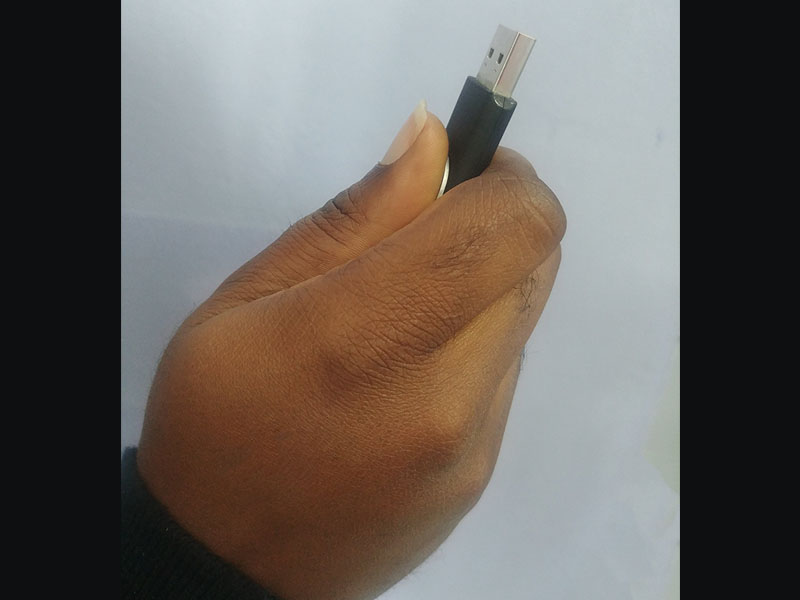 Black hands with thumb drive or USB Drive pointing upwards