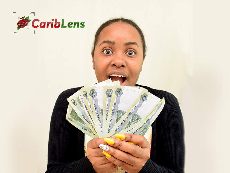 Successful black African business woman holding dollar bills in her hands – Jamaican money