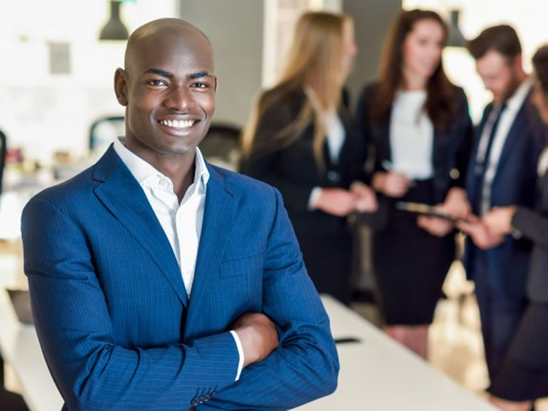 African black business man leader standing in modern office with business people working – Free Photo