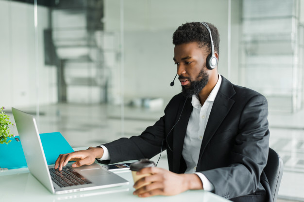 African american black man customer support operator or call centre agent with hands-free headset working in the office – Free Photo