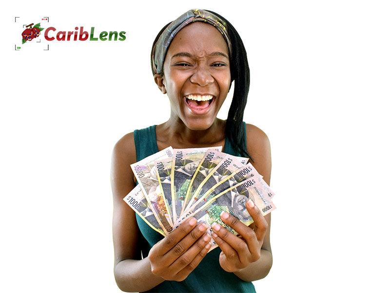 Happy African black girl or woman holding lots of Jamaican money in hands – lottery winner – free photo