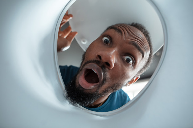 African American black man looking for something in unusual places at his home Free Photo