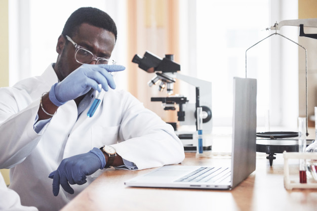 An african american worker works in a laboratory conducting experiments. Free Photo