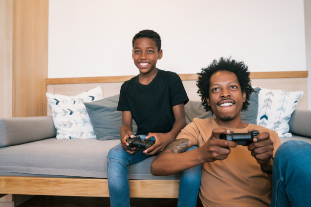 African American black Father and son playing video games together at home – Free Photo