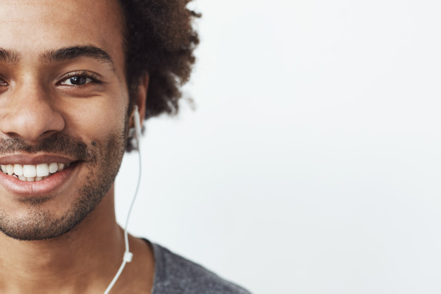 African American black man in headphones or ear buds and smiling – Free Photo