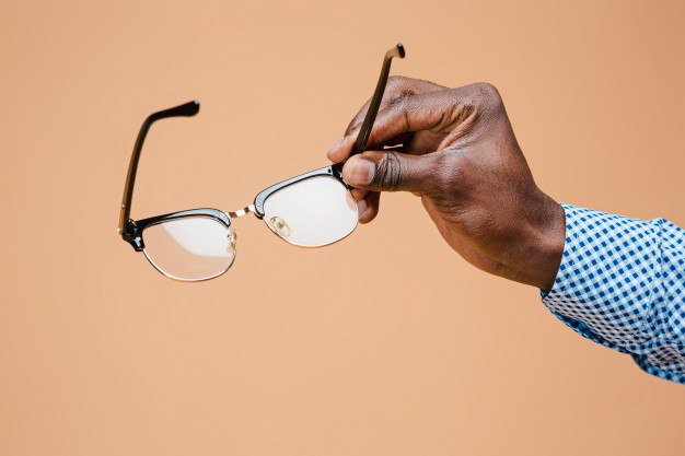 Male hand holding glasses, isolated Free Photo