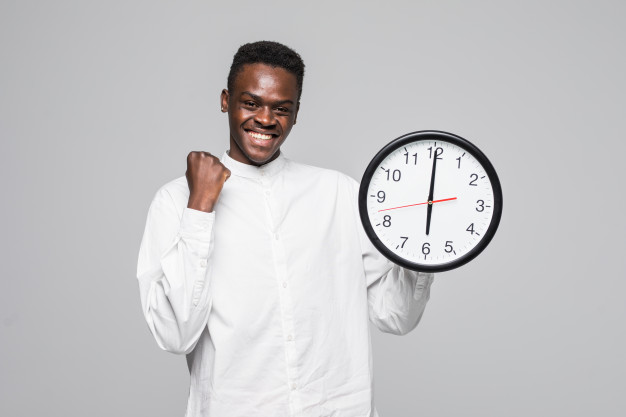 Portrait of a afro american man holding wall clock win gesture isolated on a white background Free Photo