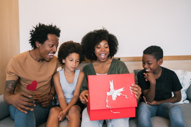 Portrait of father and children congratulate mother on mother's day and give her gifts at home. mother's day celebration concept. Free Photo