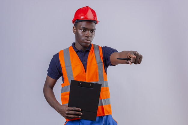 Young african american builder man wearing construction vest and safety helmet holding adjustable wrench and hammer in cross shape with serious face standing Free Photo