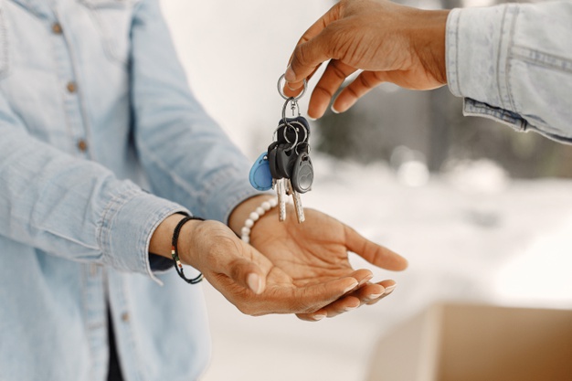 Young couple moving in to new home together. african american couple with cardboard boxes. woman hold keys. Free Photo