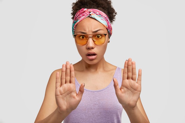 Indignant African American Female With Displeased Expression Makes Stop Gesture Rejects Something Wears Trendy Shades Casual Purple Vest Isolated White Wall Stop It Please 273609 15979