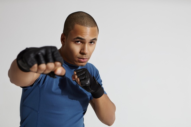 Portrait Attractive Young Mixed Race Male With Shaved Head Exercising Gym Standing White Wall Aiming Pumped Fist Camera Throwing Punch Boxing Kickboxing Martial Arts Concept 343059 462