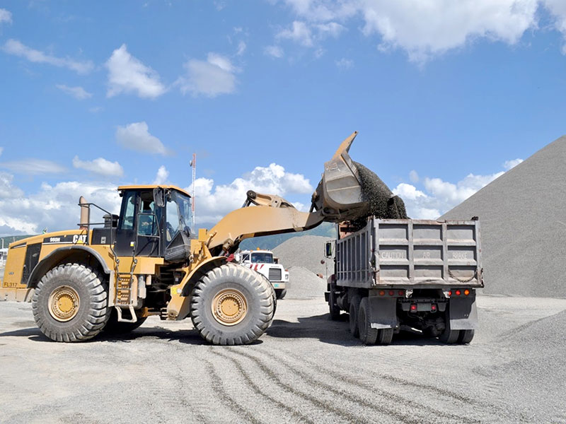 Tractor loading truck with sand or gravel