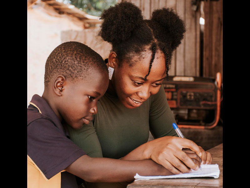 Black African woman helping boy with home work – school free photo