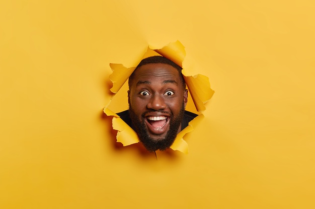 African black man head bursting through paper – free photo