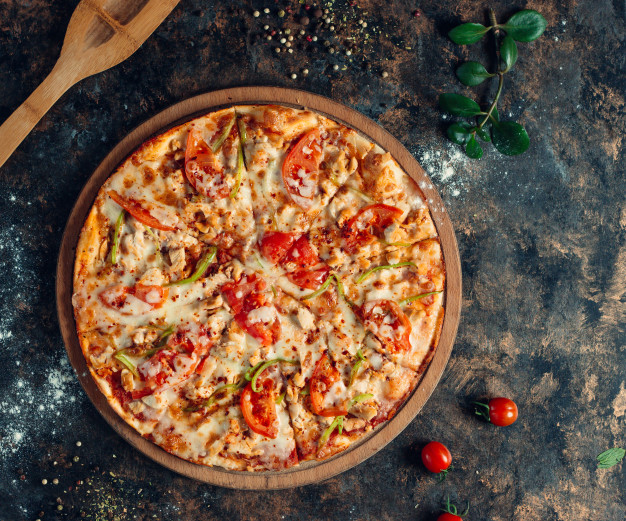 Chicken pizza with bell peppers, tomato, cheese on round wooden board Free Photo