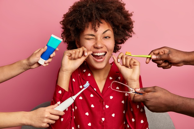 Happy Curly Young Woman Brushes Teeth With Tooth Floss Cares About Oral Hygiene Surrounded With Toothpaste Electric Toothbrush Tongue Cleaner 273609 38924