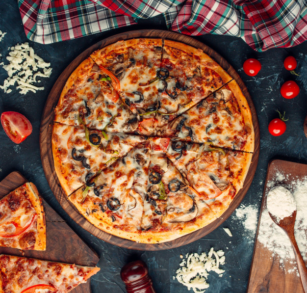 Mixed ingredient pizza with cheese and tomatoes. Free Photo