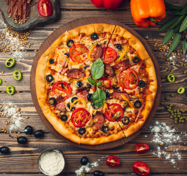 Pizza pizza filled with tomatoes, salami and olives Free Photo