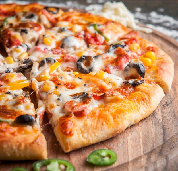 Side view pizza with chopped pepper in board cookware Free Photo