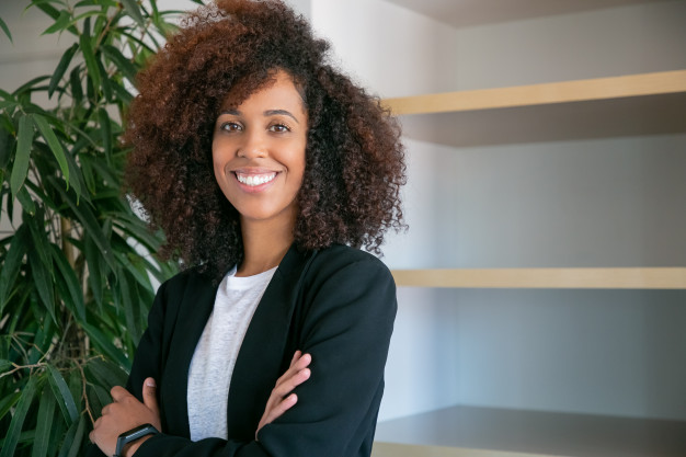 African Black curly businesswoman standing with folded hands