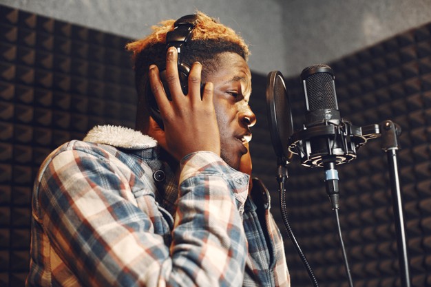 African man rehearses or singing in a recording or music studio