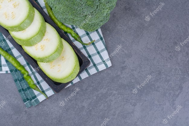 Zucchini slices with broccoli and green chilies on the ground Free Photo