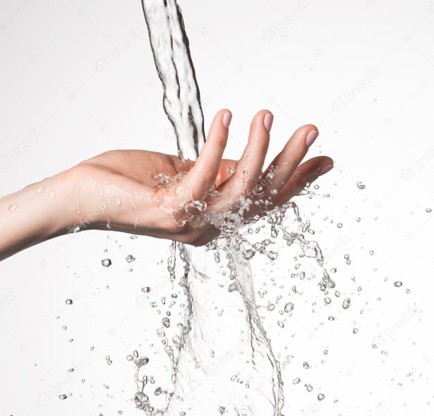 Closeup woman hand under the stream of splashing water – skin care concept Free Photo