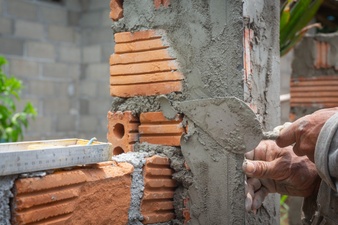 Bricklaying. construction worker building a brick wall. Free Photo