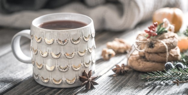 Christmas composition with cup of tea and biscuits on a wooden background, concept of holiday and fun, the background Free Photo