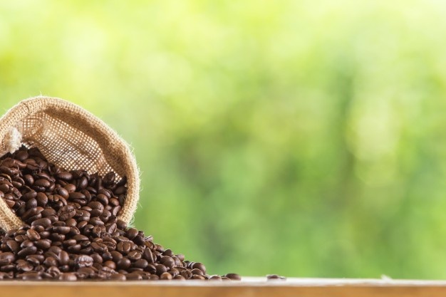 Coffee cup and coffee beans on table, top view, love coffee, brown coffee beans isolated on white background, hot coffee cup with coffee beans Free Photo