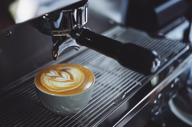 Coffee machine filling a cup Free Photo