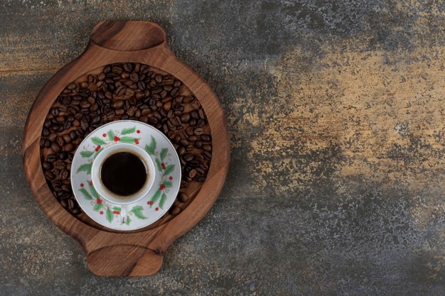 Cup of aroma espresso with coffee beans on wooden board. Free Photo