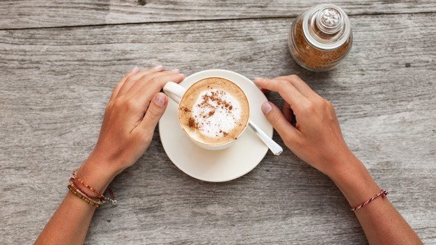 Hands hold a cup of coffee. Free Photo