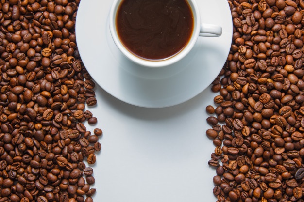 Some a cup of coffee on with coffee beans on background, top view. space for text Free Photo