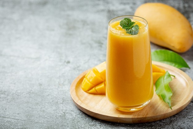 Mango juice in the glass on dark surface Free Photo