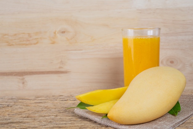 Mango juice on the wooden floor table. Free Photo