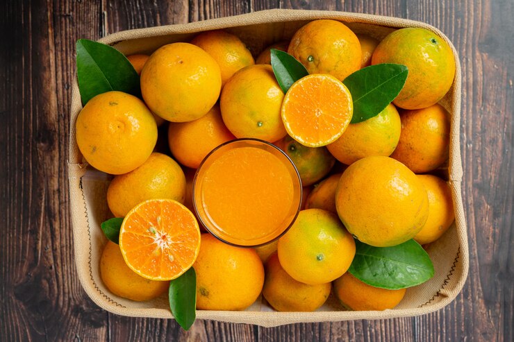 Fresh orange juice in the glass on dark wooden background Free Photo