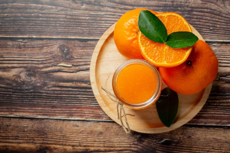 Fresh orange juice in the glass on dark wooden background Free Photo