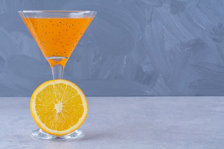 Fresh orange juice next to slice orange on the marble. Free Photo