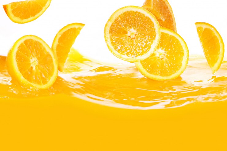 Fresh oranges falling in juice Free Photo