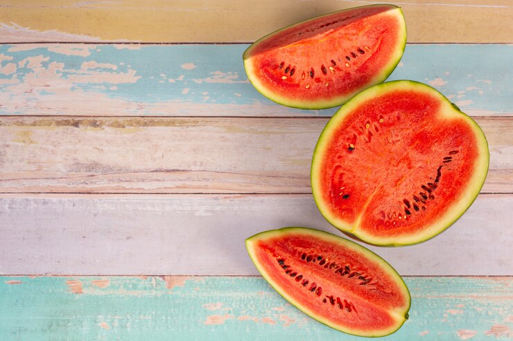 Freshly sliced red watermelon on a wooden board wall Free Photo