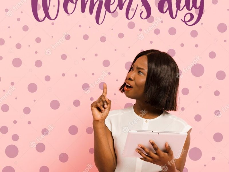 African black woman holding a pink tablet pointing up – Girl Power