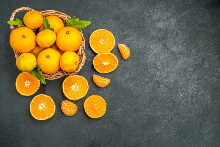 Top view fresh mandarines in wicker basket on dark background Free Photo