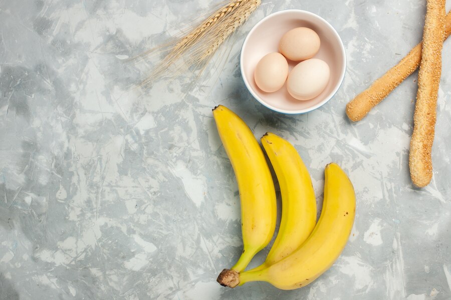 Top View Yellow Bananas With Raw Eggs Bun Bread Light White Desk 140725 58533