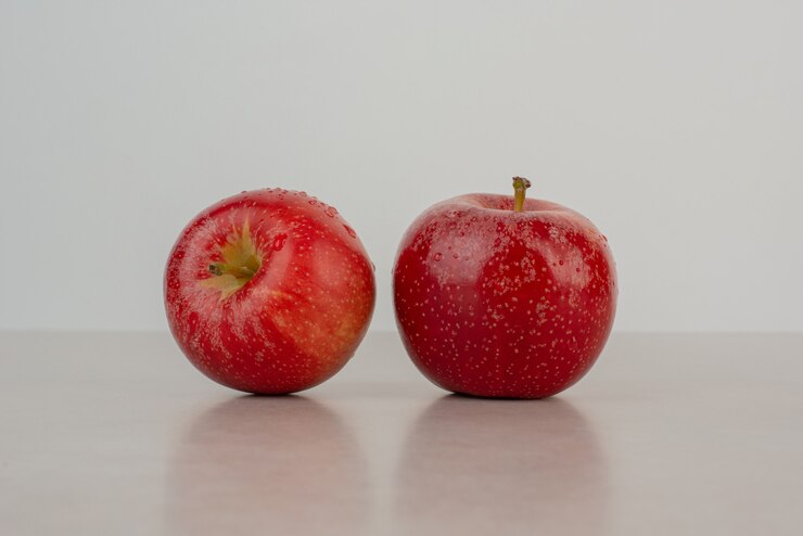 Two red apples on marble table . Free Photo